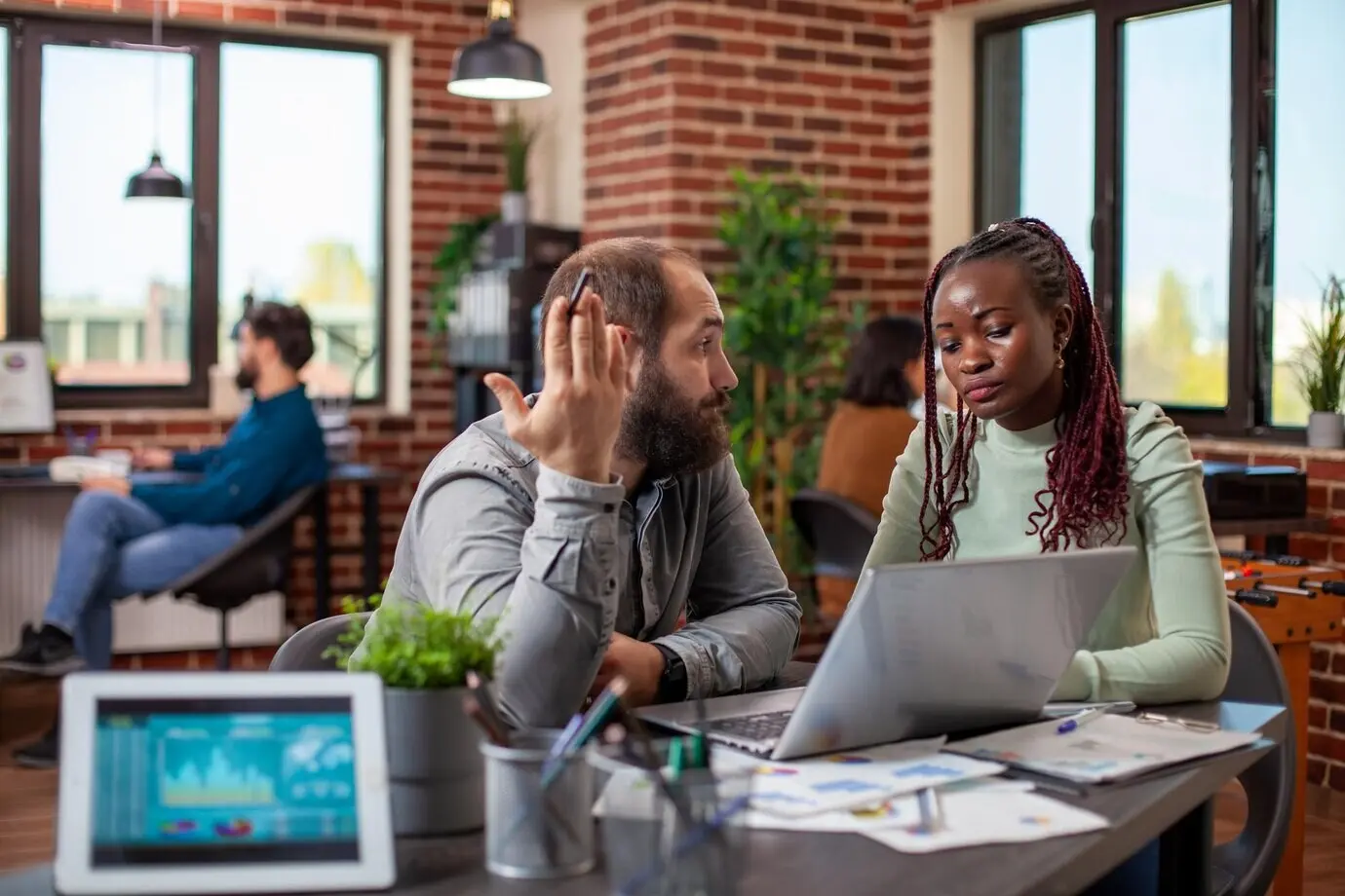 Kollegen analysieren Strategien an einem Laptop